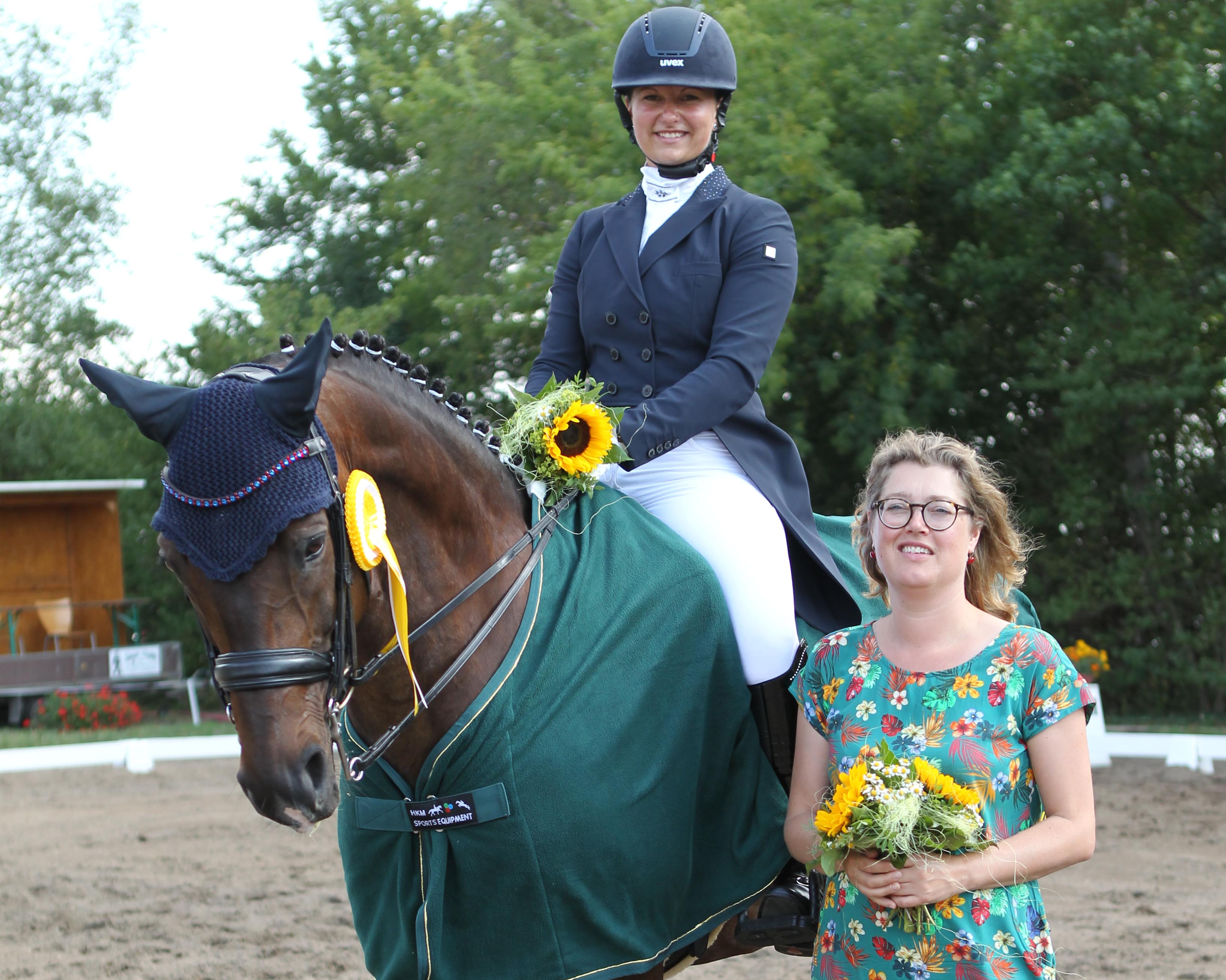 Susanne Voß aus Laage, die für den RV Güstrow reitet, gewann mit San Amour die Zwei-Sterne M-Dressur und war schon 2019 mit Siegen in den zwei Hauptprüfungen erfolgreich. Linda Tuienir Hofmann-Huijssoon von der Agrargenossenschaft Stove, seit Jahren großzügige Förderer des Turniers, gratuliert. Foto: Jutta Wego