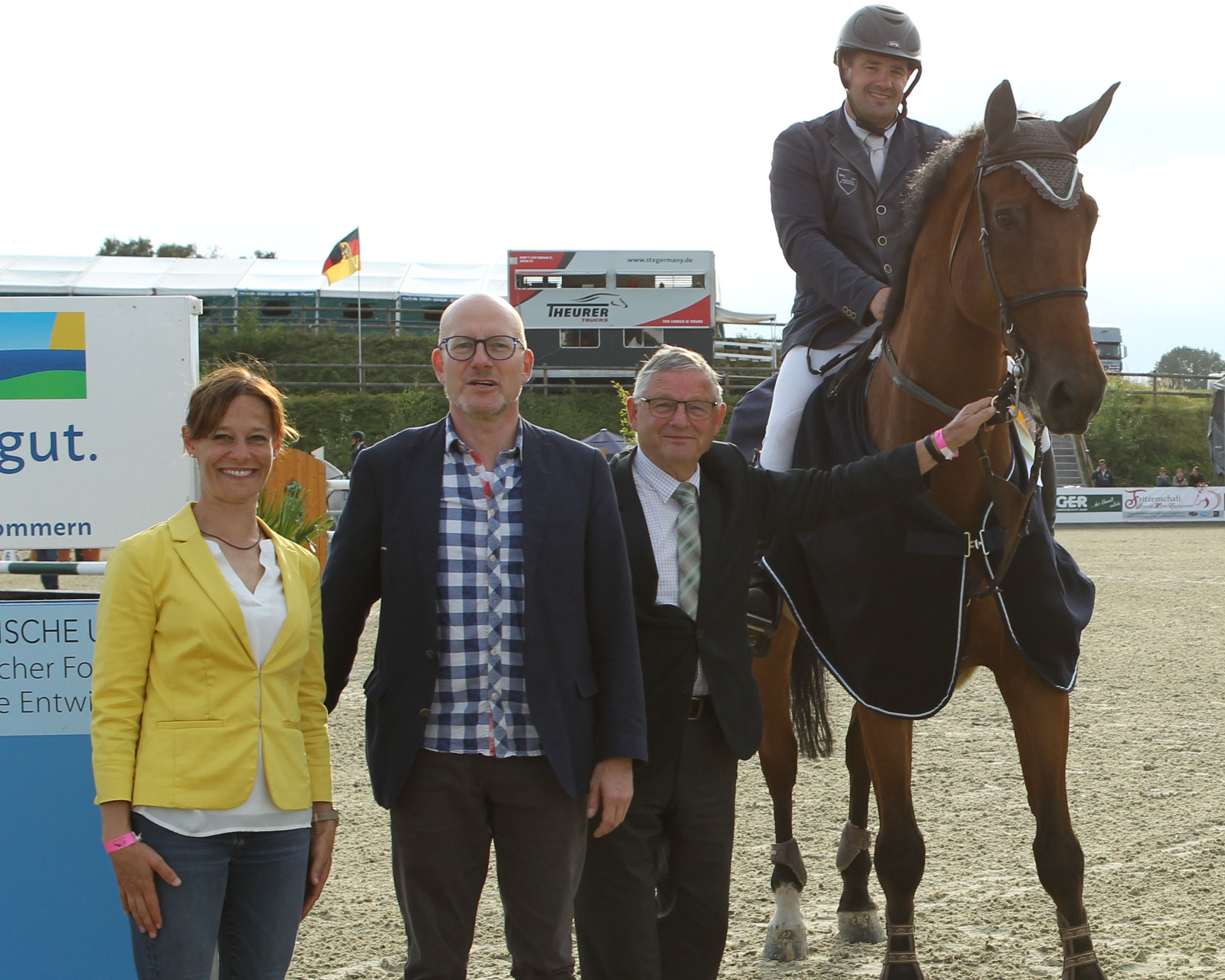 Turnierleiterin Kathrin Wiedmer, Peter Kranz von Landesmarketing Mecklenburg-Vorpommern und Jurymitglied Franz Wego gratulieren Benjamin Wulschner zum Sieg im Großen Preis. © Jutta Wego