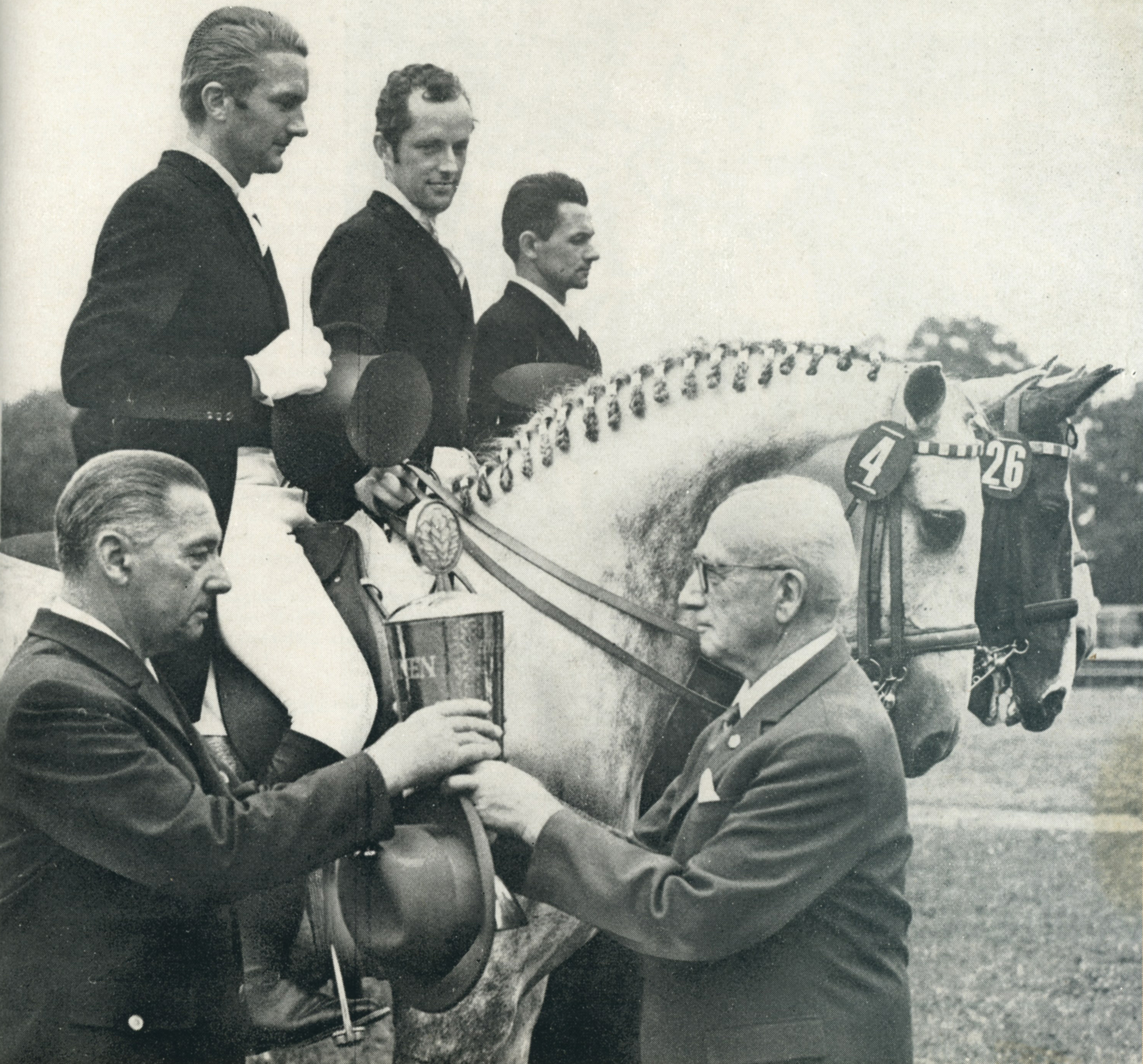 Wolfgang Müller (r. auf Semafor), beim Nationenpreissieg in Lepzig mit seinen Teamkollegen Gerhard Brockmüller auf Tristan (Mitte) und Horst Köhler auf Alfermat mit Trainer Willi Lorenz, der den Siegerpokal aus den Händen von Arno von Lenski erhältentgegen nimmt. © Mihatsch