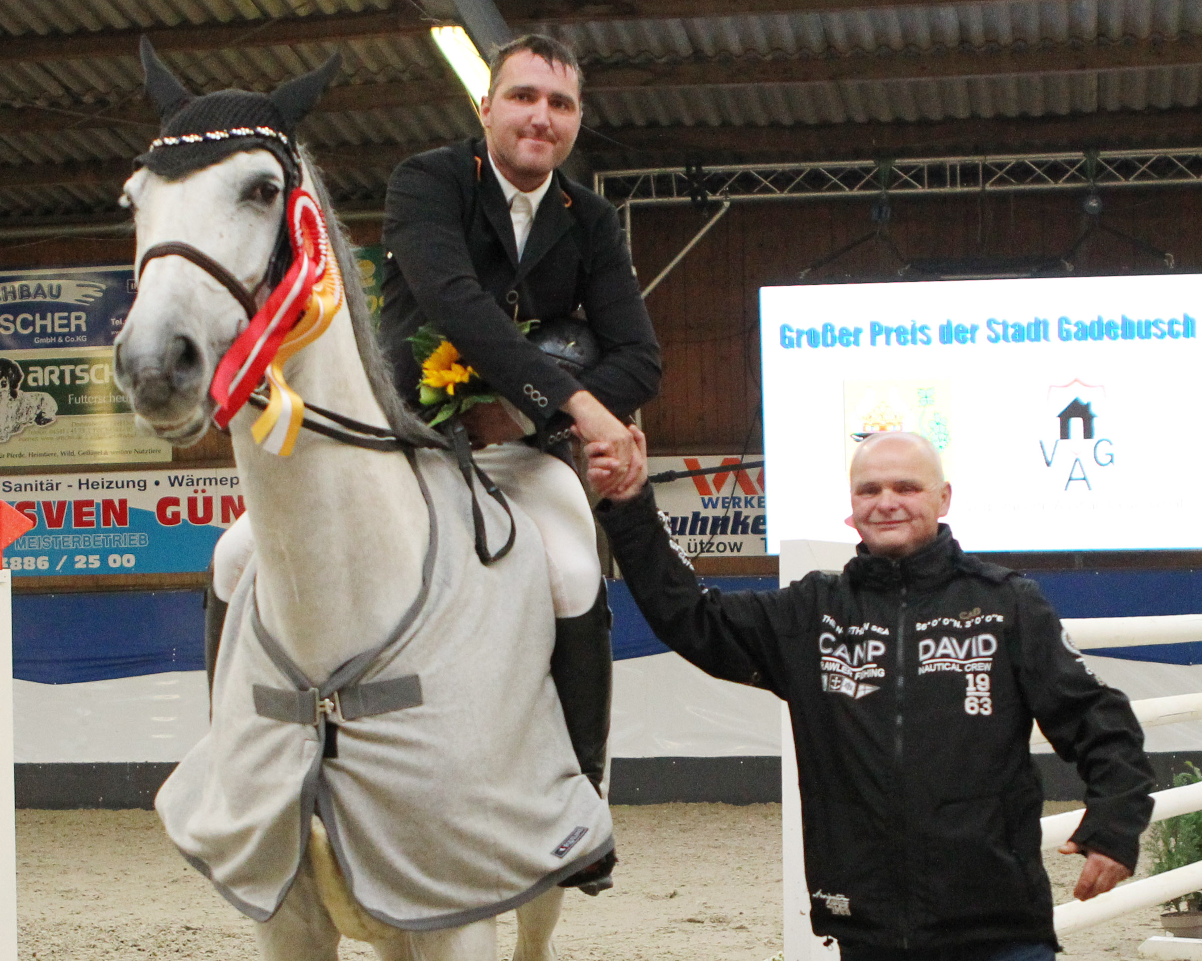 Andreas Neumann von der Vorpommerschen Ausbau Gesellschaft, einer der bedeutendsten Sponsoren des Springsports in MV, hat auch das 27. Hallenturnier in Gadebusch gefördert und gratuliert Max-Hilmar Borchert zum Sieg im Großen Preis. © Jutta Wego