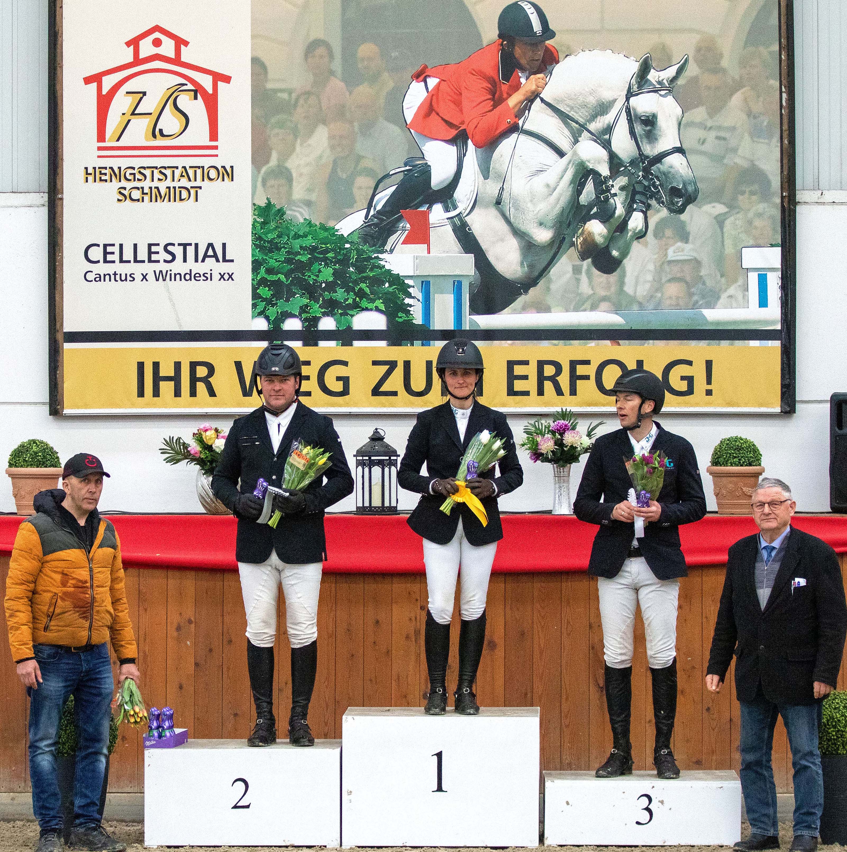Auf dem Podium bei der Siegerehrung zum Großen Preis vor dem Konterfei des Neu Benthener Stationsgründers Cellestial: Siegerin Anna Ebel-Jürgens, Zweiter Ronny Sauer, Dritter Ulf Ebel. Turnierleiter Heiko Schmidt und Turnierrichter Franz Wego gratulieren. © KaLo
