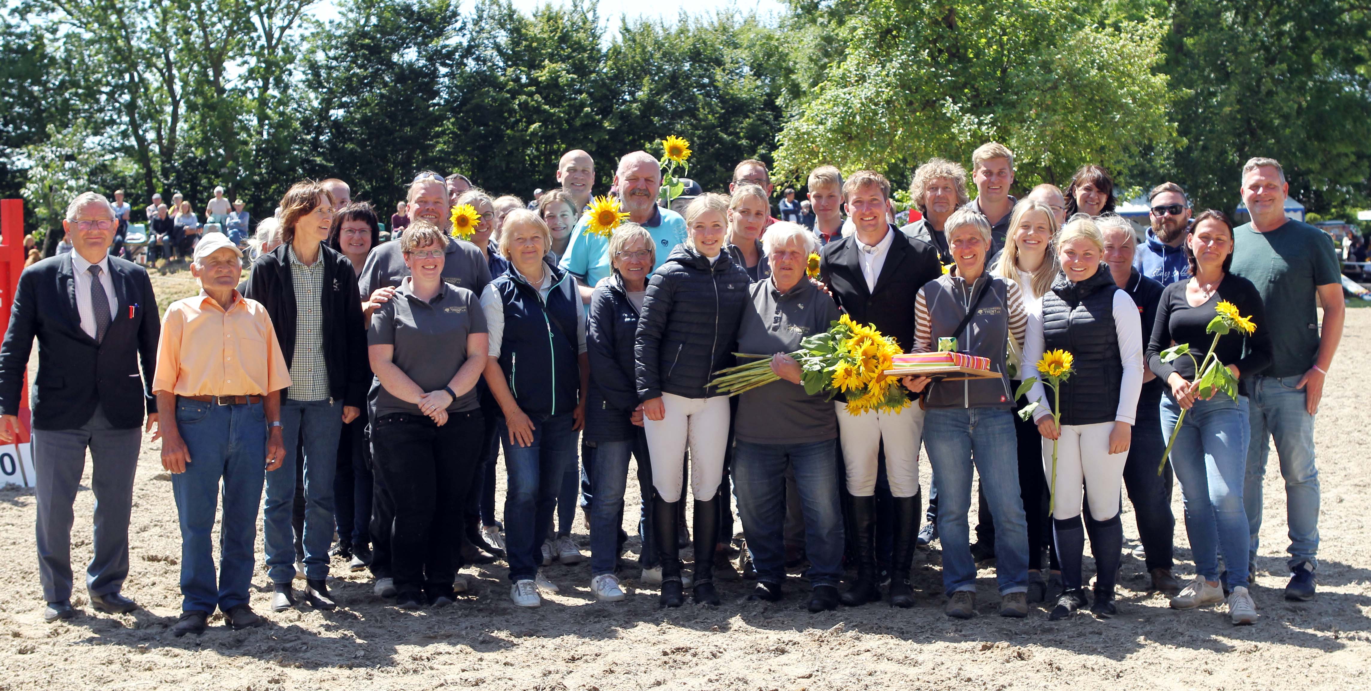 Vereinsmitglieder, Freunde und ihre Enkel kamen nach der Auszeichnung mit Sonnenblumen auf den Platz in Zubzow um Margitta Wiktor zu gratulieren. © Jutta Wego