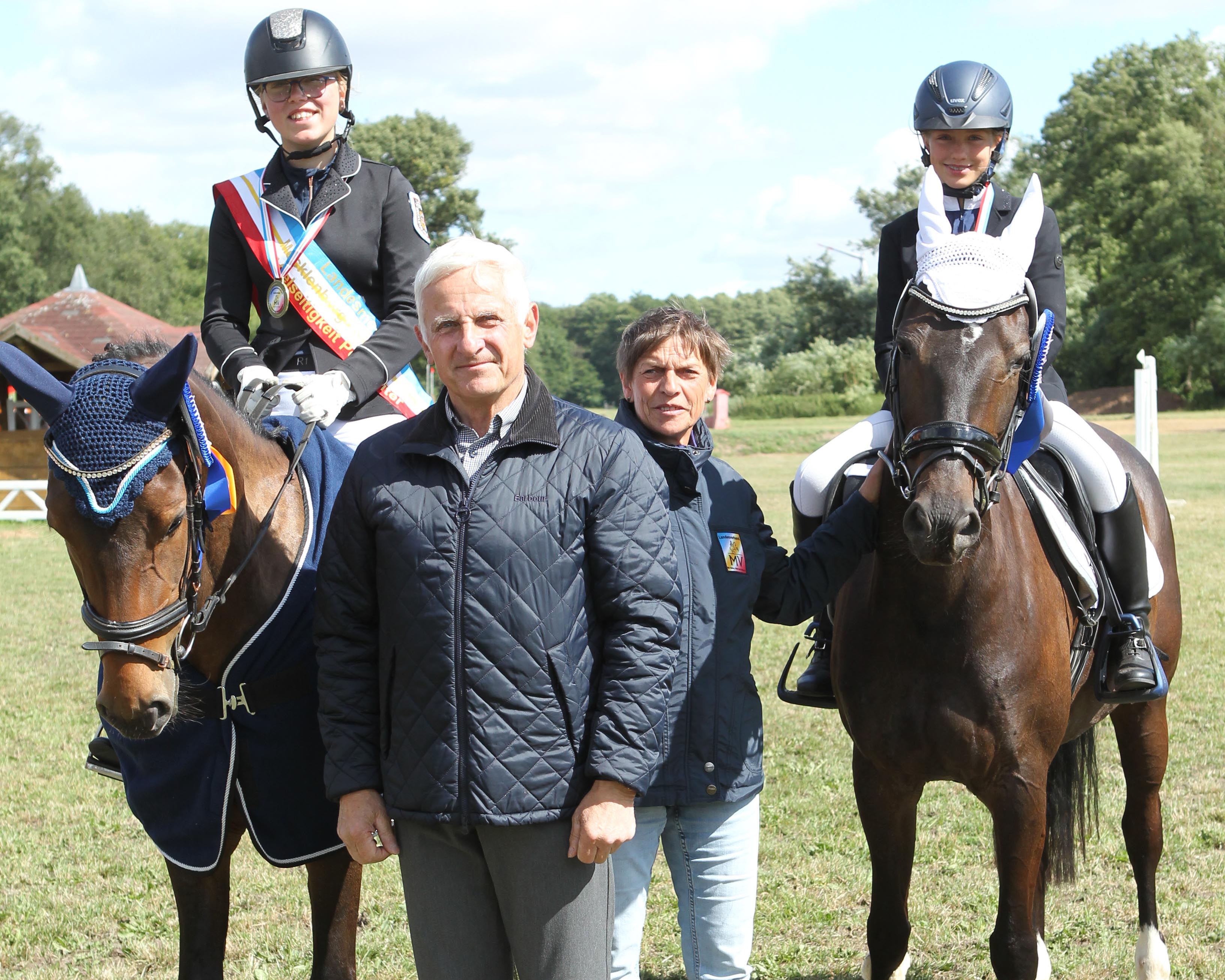 Verbandspräsident Dr. Burkhard Dittmann und Landestrainerin Elke Spierling gratulieren die Pony-Landesmeisterin Hanna Marie Koubin und Vizemeisterin Lilly Charlott Hagemann. © Jutta Wego