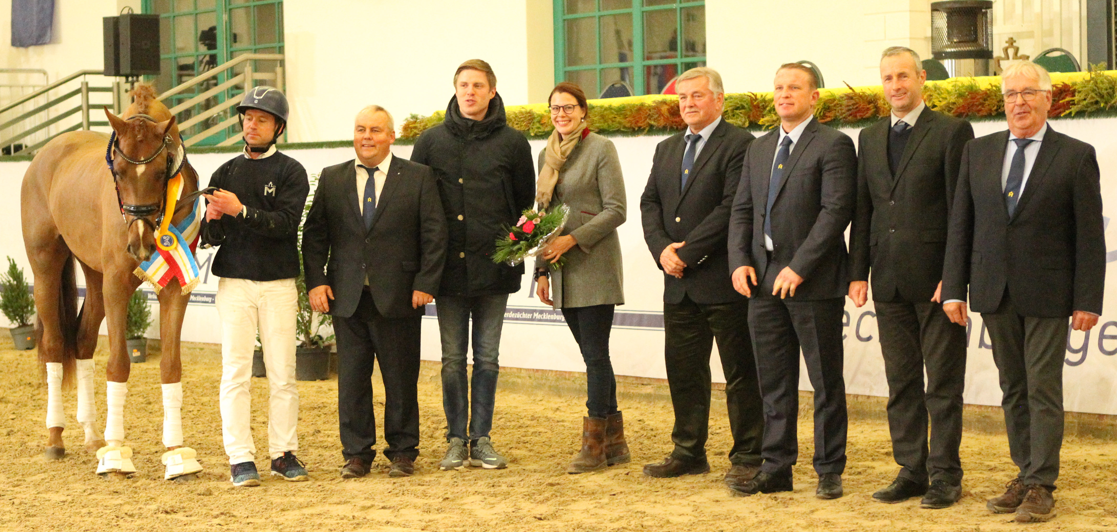 Der Dressursiegerhengst mit seinem Ausbilder Christoph Hinkel und v.l. MV Zuchtverbandspräsident Jörg Hasselmann, Lukas Fischer, sowie die Körkommission Karoline Gehring, Jörg Weinhold, Thomas Kleis, Ronald Lüders und Hans-Heinrich Brüning. © Jutta Wego