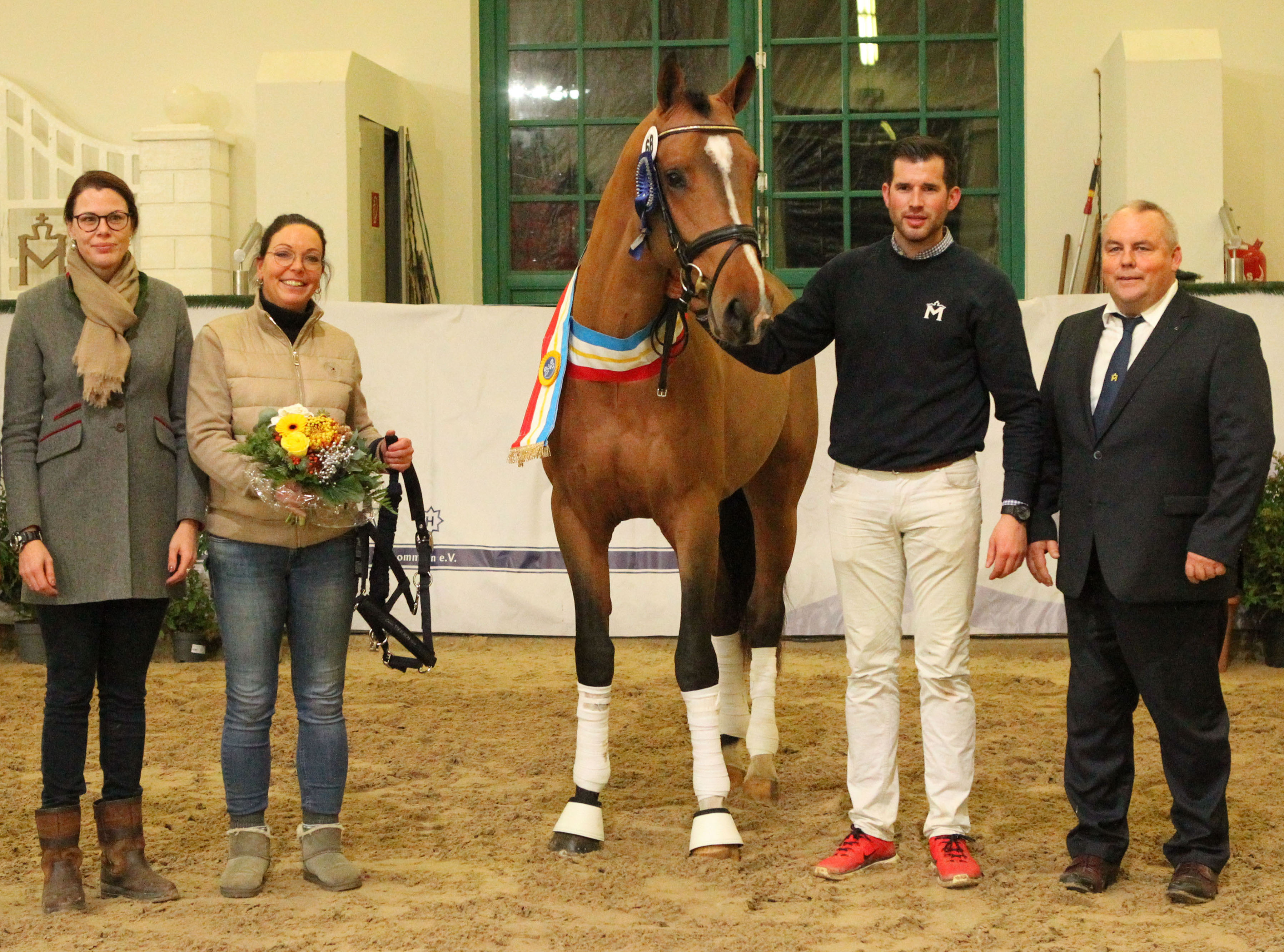 Der Siegerhengst Springen Kat. Nr. 68 bei der Prämierung mit seiner Besitzerin Nicole Derlin (mit Blumenstrauß), Zuchtleiterin Karoline Gehring, Lukas Kückelhaus (am Pferd) und MV Zuchtverbandspräsident Jörg Hasselmann. ©