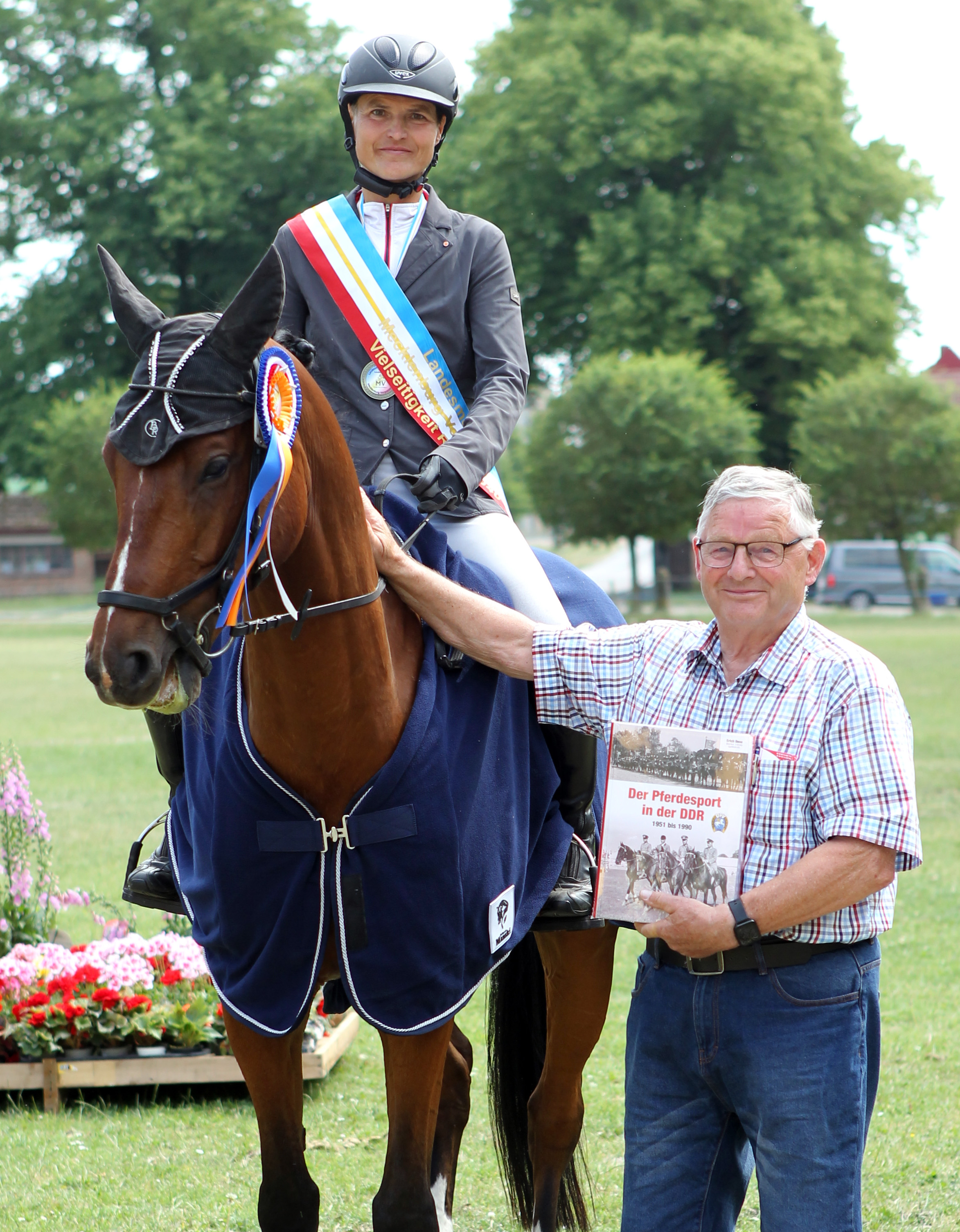 Ü40-Landesmeisterin Marianne Bürenheide erhielt als Sonderehrenpreis das Buch Der Pferdesport in der DDR 1951-1990 aus der Hand des Herausgebers Franz Wego.