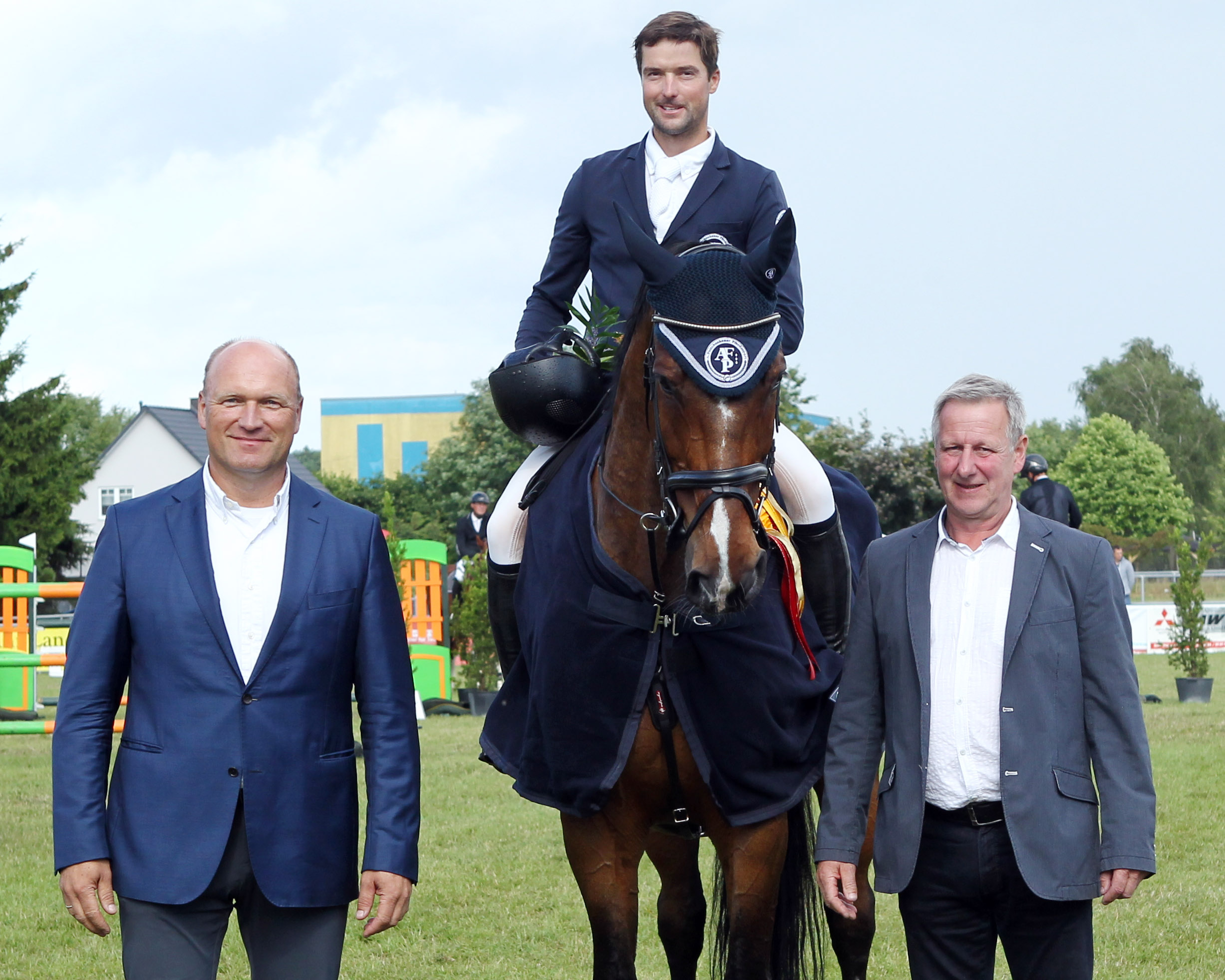 Carsten Stegelmann (GF der Agrar GmbH Dersekow) und Turnierleiter Torsten Lanske gratulieren Pfilipp Makowei zum Sieg im Großen Preis. © Jutta Wego