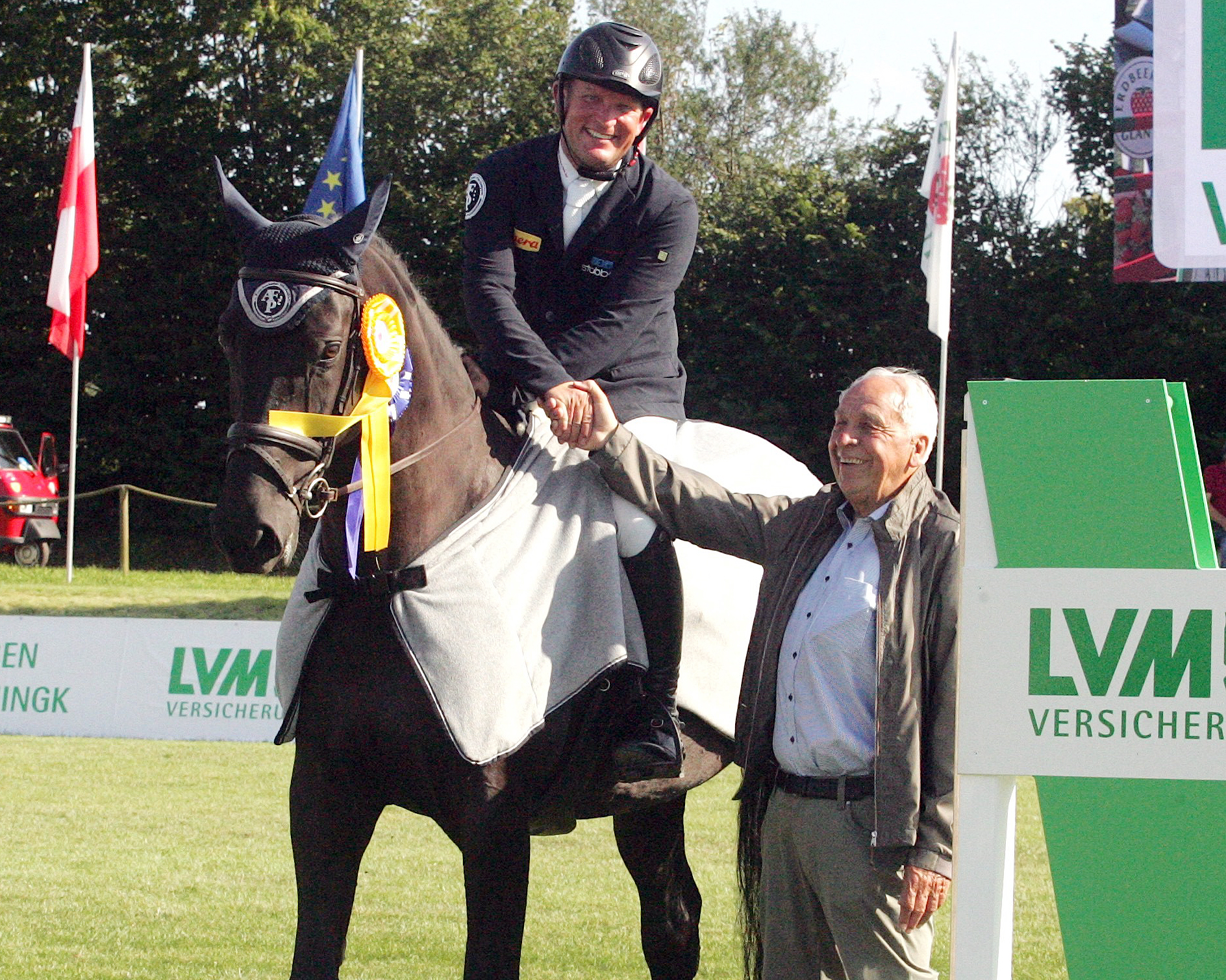 Enno Glantz, Initiator des Events auf seinem Erdbeer-Hof, gratuliert Thomas Kleis zum Sieg mit Silberpfeil M im S-Springen am Freitag. © Martina Brüske