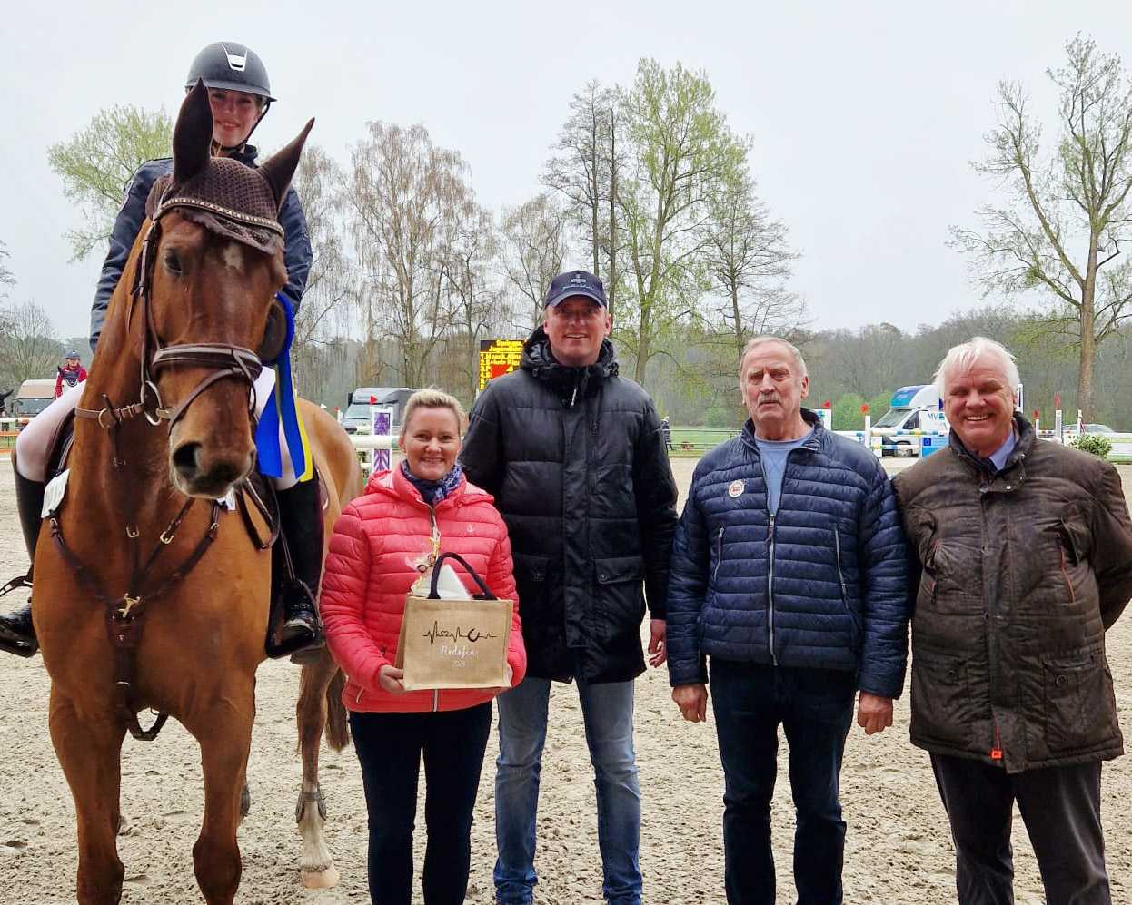 Die Sponsoren Christin Romanowski, amtierende Gestütsleiterin, Dieter Brüsch, Vorsitzender des Pferdezuchtvereins Redefin, dazwischen Turnierleiter Heiko Strohbehn und Hans-Joachim Begall, Verbandspräsident und Richter der Prüfung, gratulieren Alina Maack zum Sieg. © Annett Strohbehn