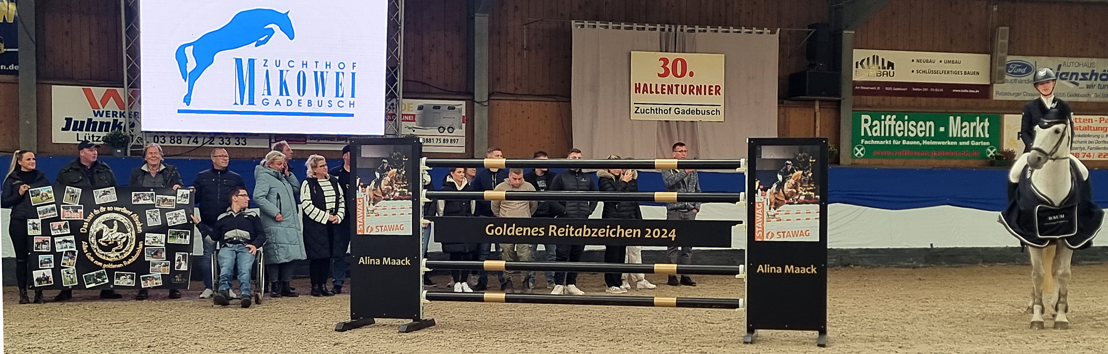 Eine großen Fangemeinde, zu der auch Markus Claßen (im Rollstuhl rechts) aus Aachen gehört, der eigens dazu anreiste und selbst das Wort ergriff, versammelte sich hinter einem Tuch mit Fotos und einem Hindernis das das Ereignis symbolisiert, bei der Abzeichen Übergabe. © J.Wego