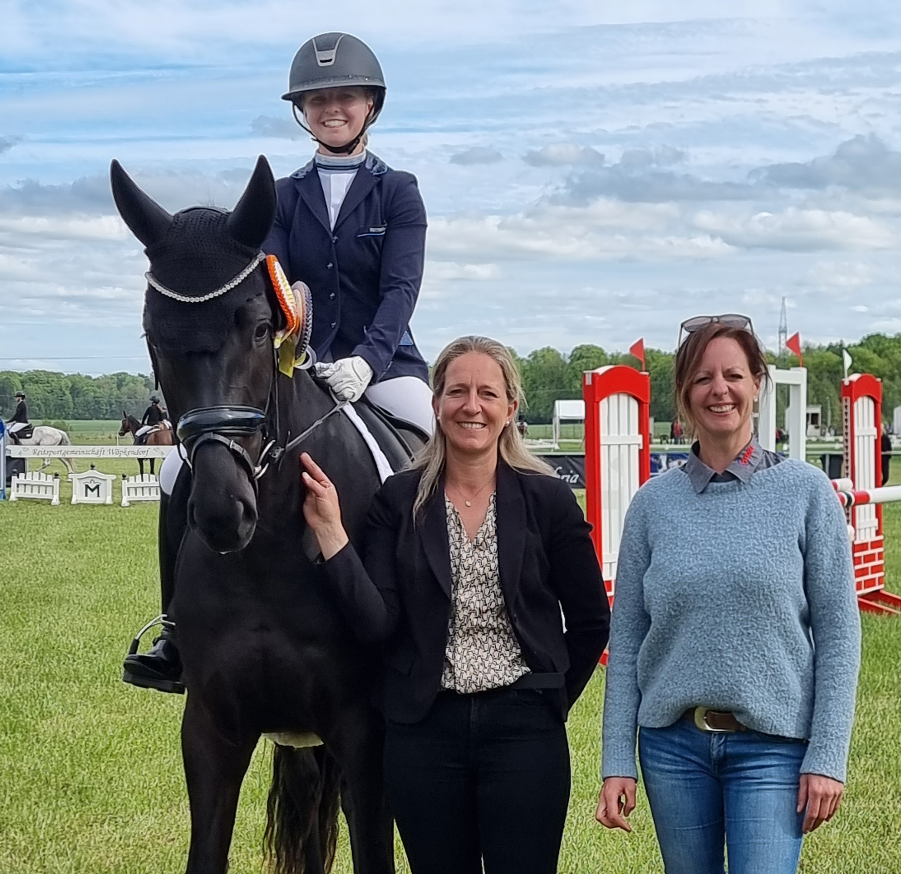 Sponsorin Nicole Steinke (r.) und Anne Grawe vom Veranstalter gratulieren Paulin Lutze (Greifswalder Akademischer RV) zum Sieg in der Dressurpferdeprüfung auf der 4-jährigen Stute Secret’s Girl. © J. Wego