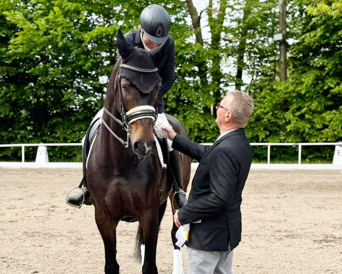 Richter Dieter Krull aus Sachsen-Anhalt gratuliert dem Sieger Ronald Lüders, der mit seiner eigenen Stute Bella den Sol die Zwei-Sterne M-Dressur M11 gewonnen hat. © K.W.