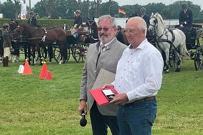 Fahr-Ausschuss-Vorsitzender Rainer Bruelheide (li.) zeichnet Hans-Georg Schröder mit dem bronzenen Reiterkreuz beim internationalen Turnier in Lähden aus. © privat