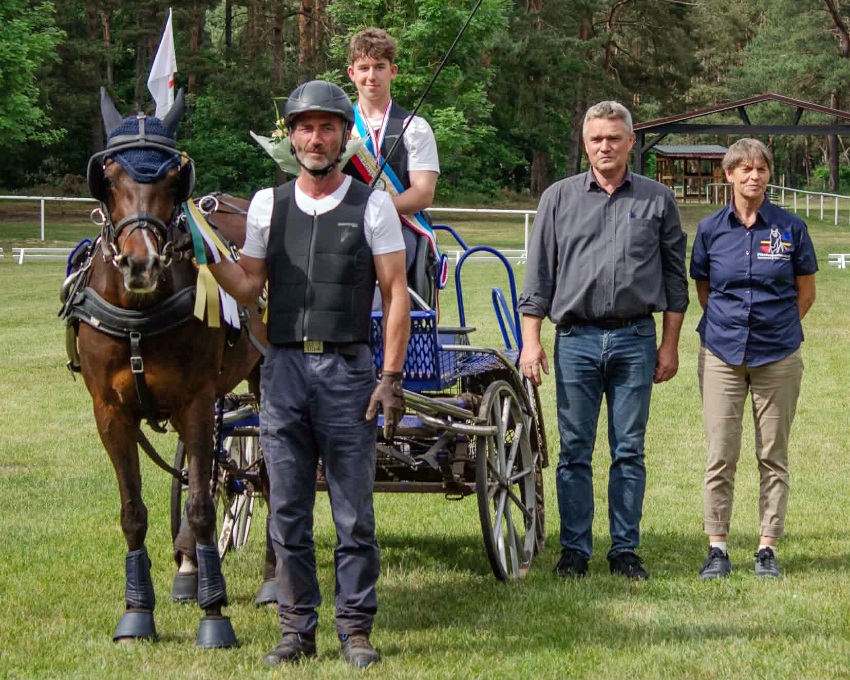Der neue Landesmeister im Einspännerfahren mit Ponys – Jonas Drews vom RFV Am Aubach Alt Meteln mit dem 8-jährigen Deutschen Reitpony Rylana MG. Turnierleiter Mario Hobom, Elke Spierling als Vertreterin des Landesbandes gratulieren Jonas und seinem Vater Christian Drews. © Kerstin Hobom