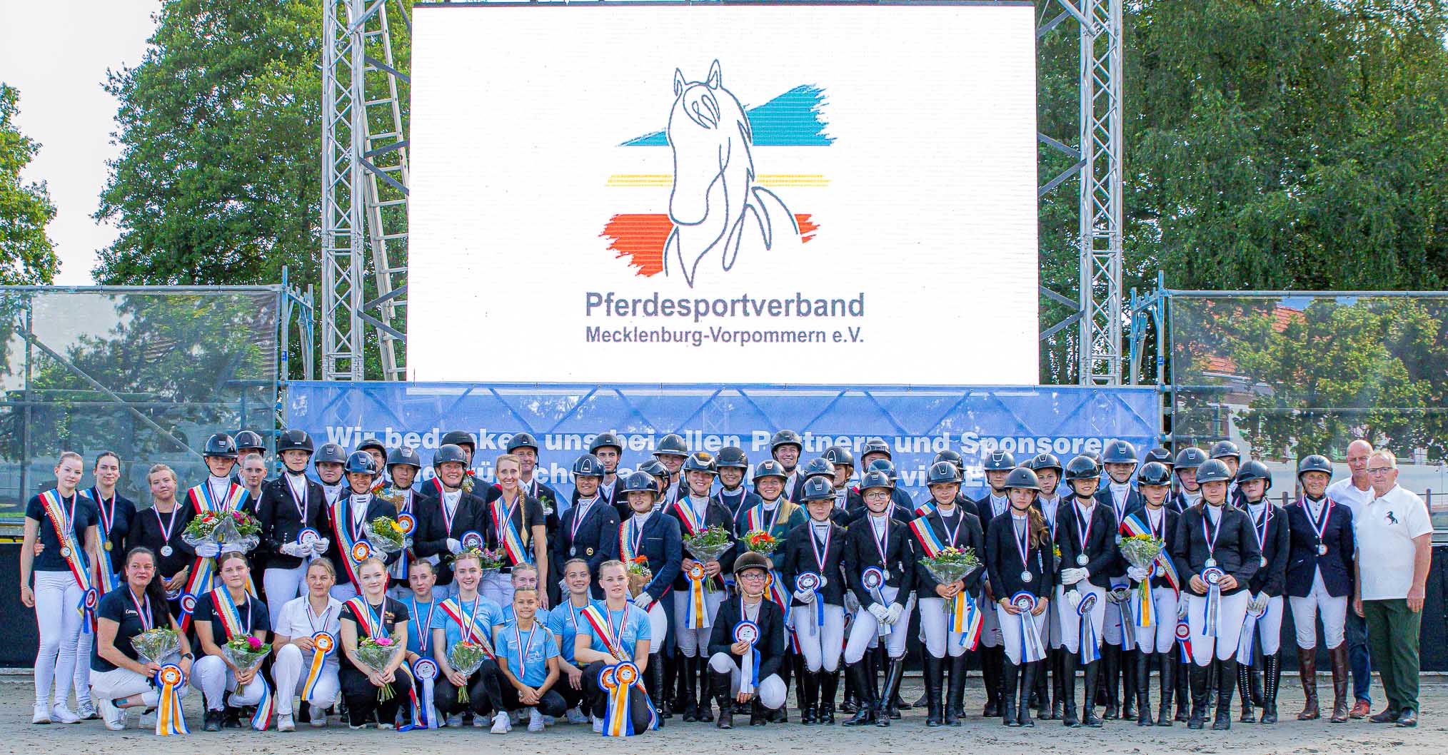 Alle 52 Medaillengewinner im Dressurreiten, Springreiten und Voltigieren mit dem Schirmherr Dr. Till Backhaus und Turnierleiter Sven Strauß (r.) beim 37. Landesturnier im Landgestüt Redefin. © Sophia Boge