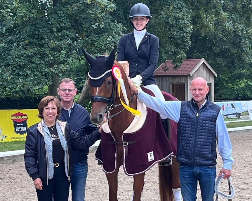 Katja Gleisner vom (Trainingsstützpunkt Güstrow) hat sich mit zwei Siegen auf Negros son den Meistertitel bei den Ü40 Amateuren geholt. Der Fliesenleger Ralf Kowalke mit Ehefrau als Sponsor und Turnierleiter Sven Strauß gratulieren. © Christina Schulz